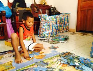 Jerry assembles the giant puzzles from the toy library