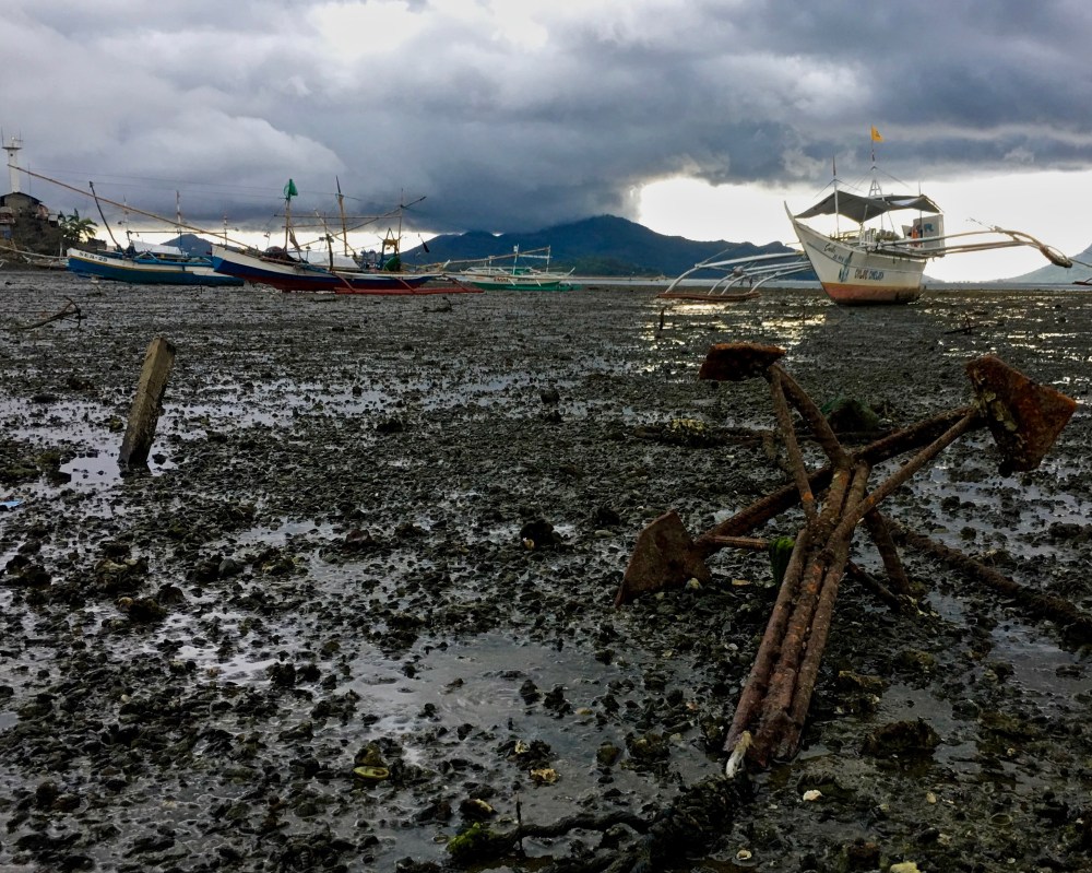 late afternoon rain clouds and a very low tropical tide in Estancia, Philippines.