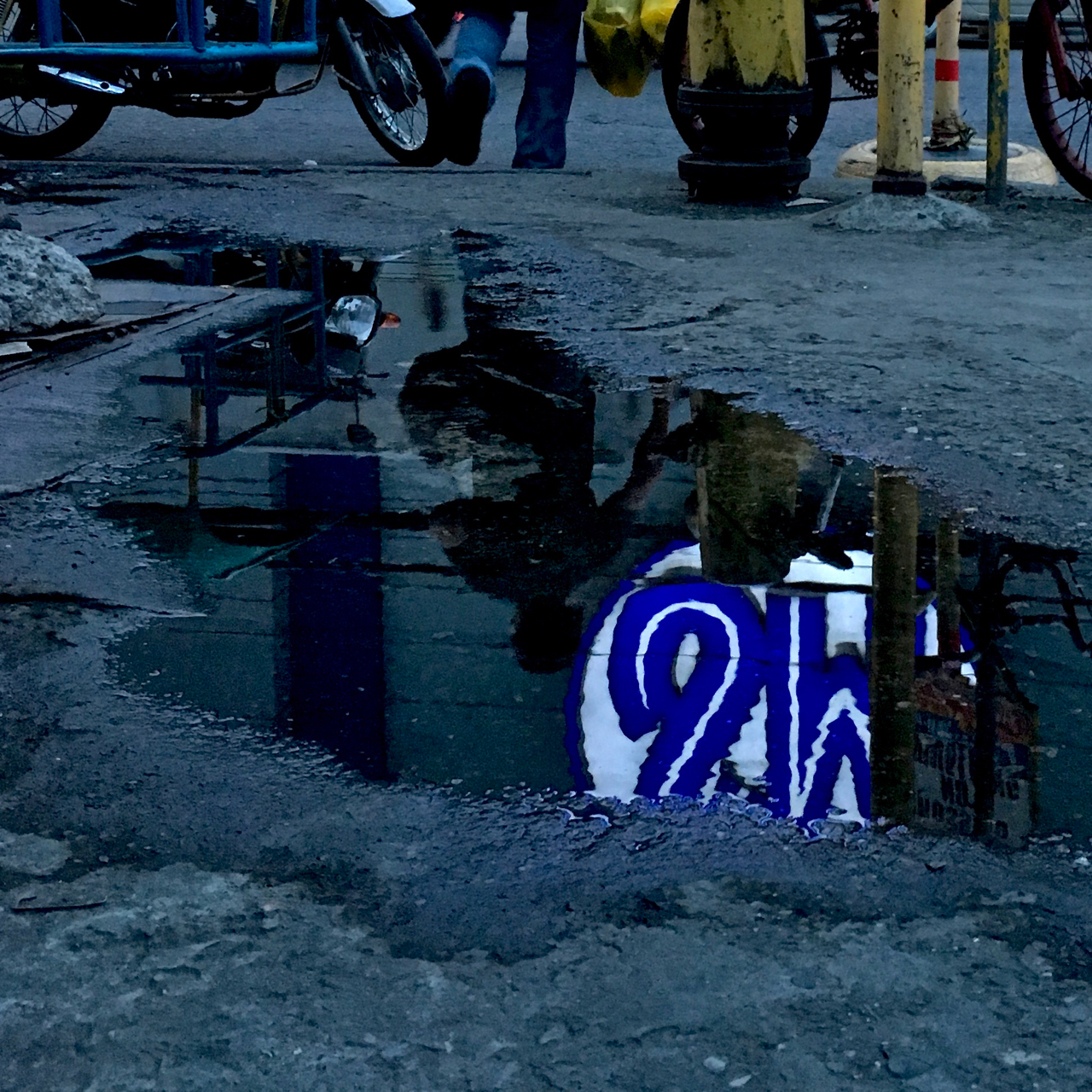 SM Mall logo reflected into a puddle
