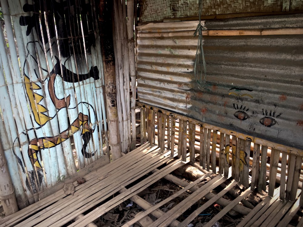 dilapidated bamboo shack with street art type motifs
