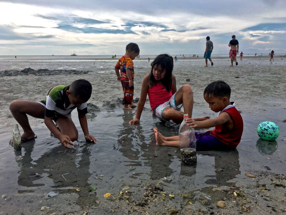 kids on the beach catching tiny fish
