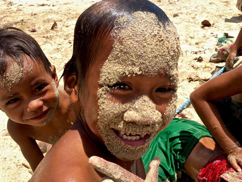 impoverished island kids of the Philippines covered in sand