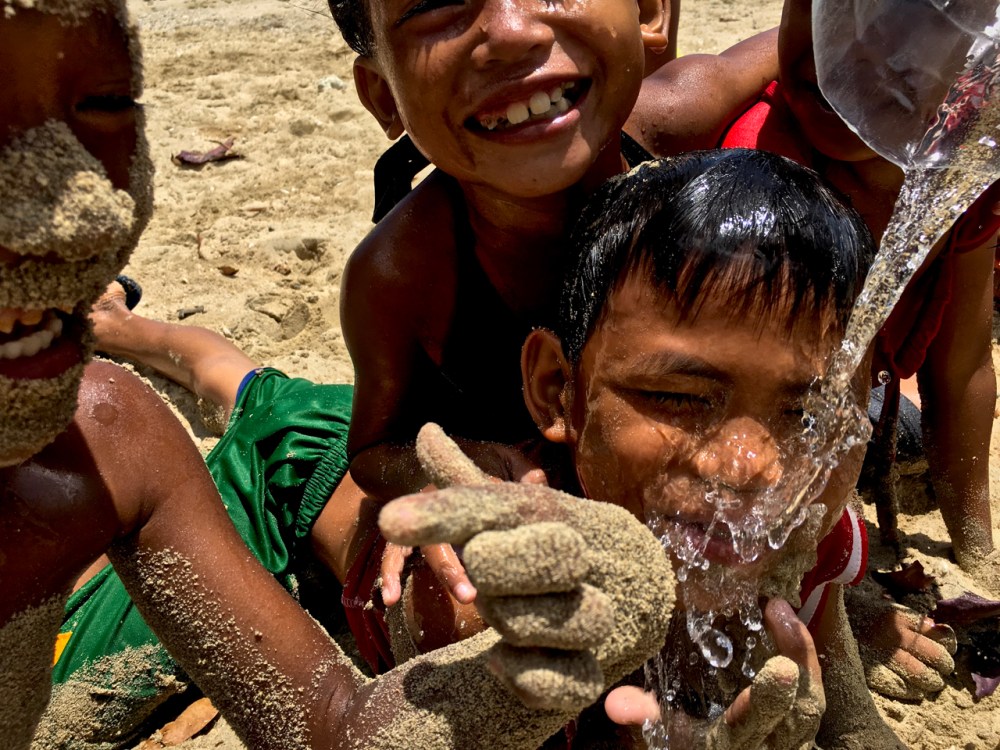 impoverished island kids of the Philippines covered in sand