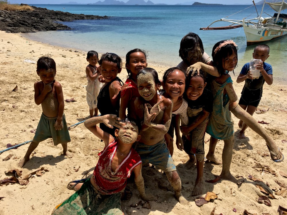 impoverished island kids of the Philippines covered in sand
