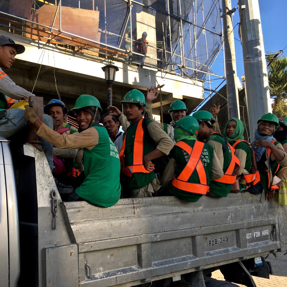 workman load into the back of a truck in the philippines
