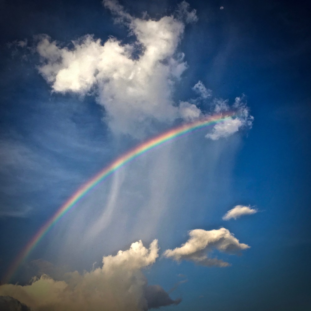 rainbow above the clouds and under the moon