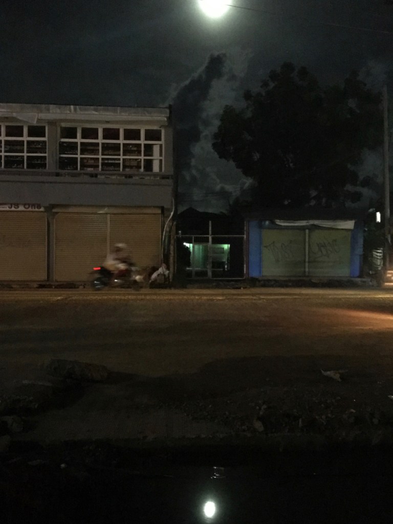 full moon reflecting over a motorbike and a puddle