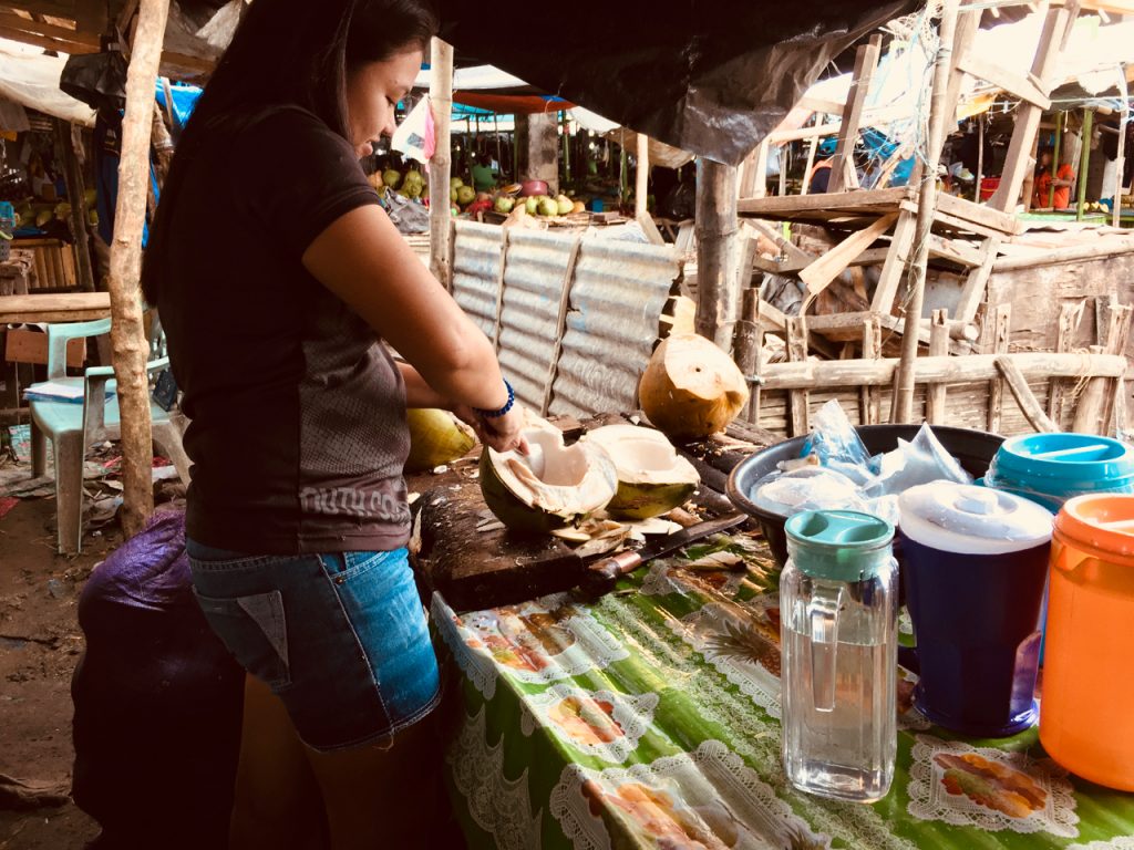 girl cutting coconuts